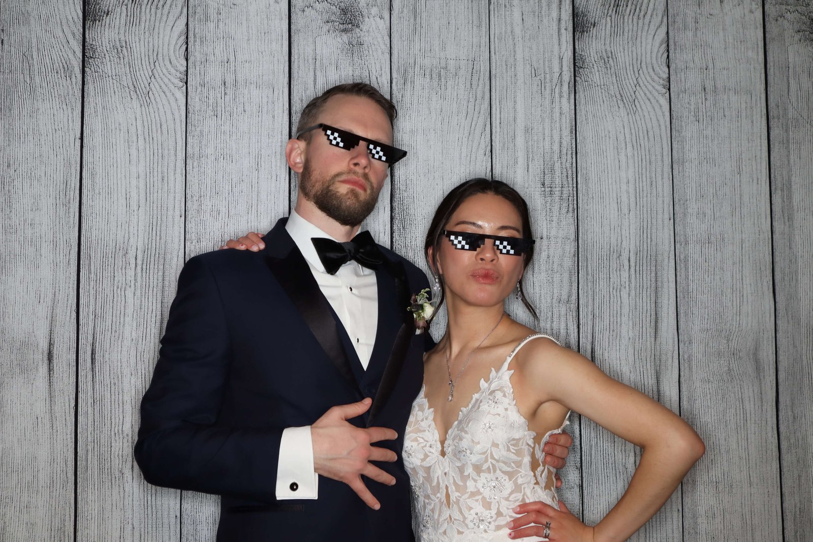 An elegant brid and groom posing at Peinc Studio photo booth with wood vinyl backdrop